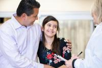 Father And Daughter Having Consultation With Female Pediatrician
